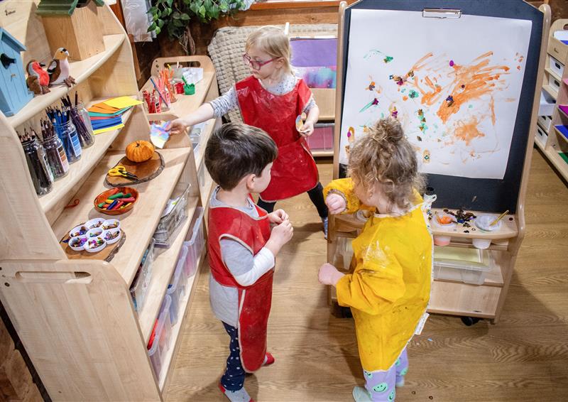 A group of three children are playing with Millhouse indoor classroom furniture